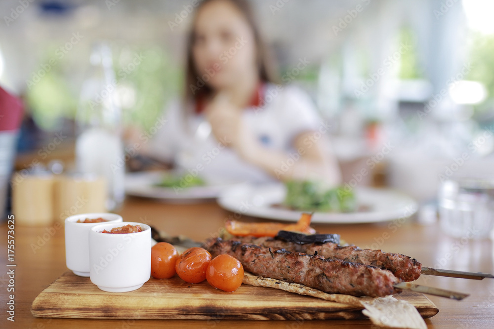 Woman having lunch in summer restaurant blurred background