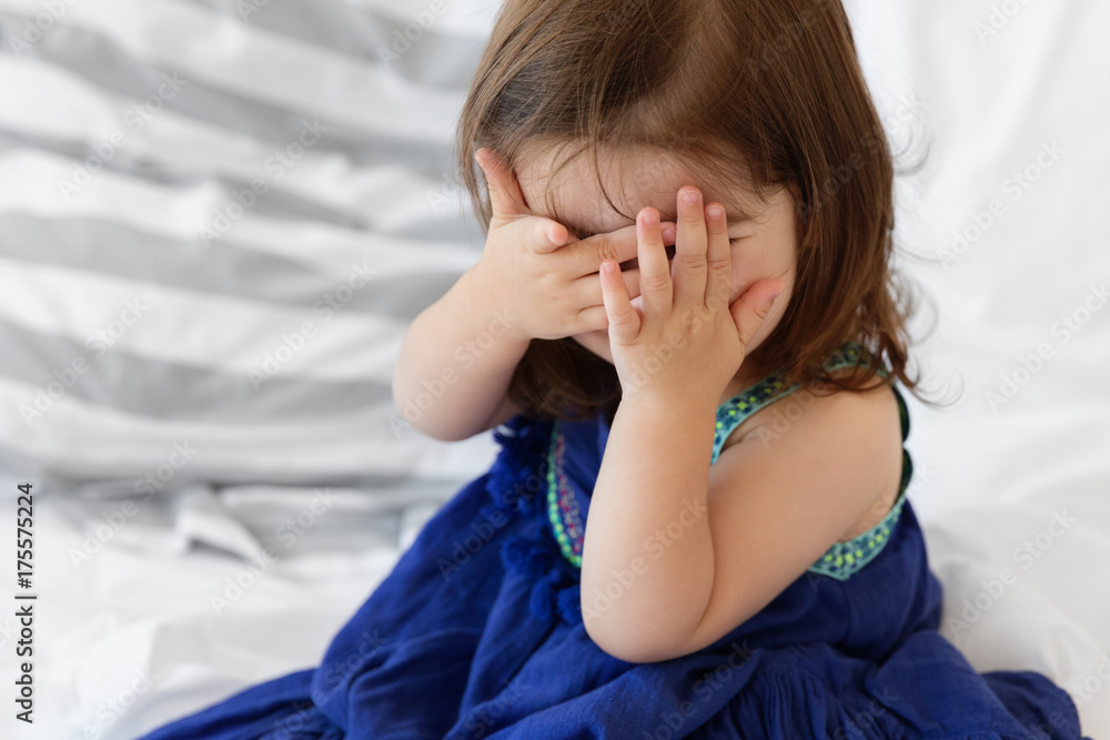 baby girl playing peek-a-boo with hands on face baby girl playing peek-a-boo with hands on face