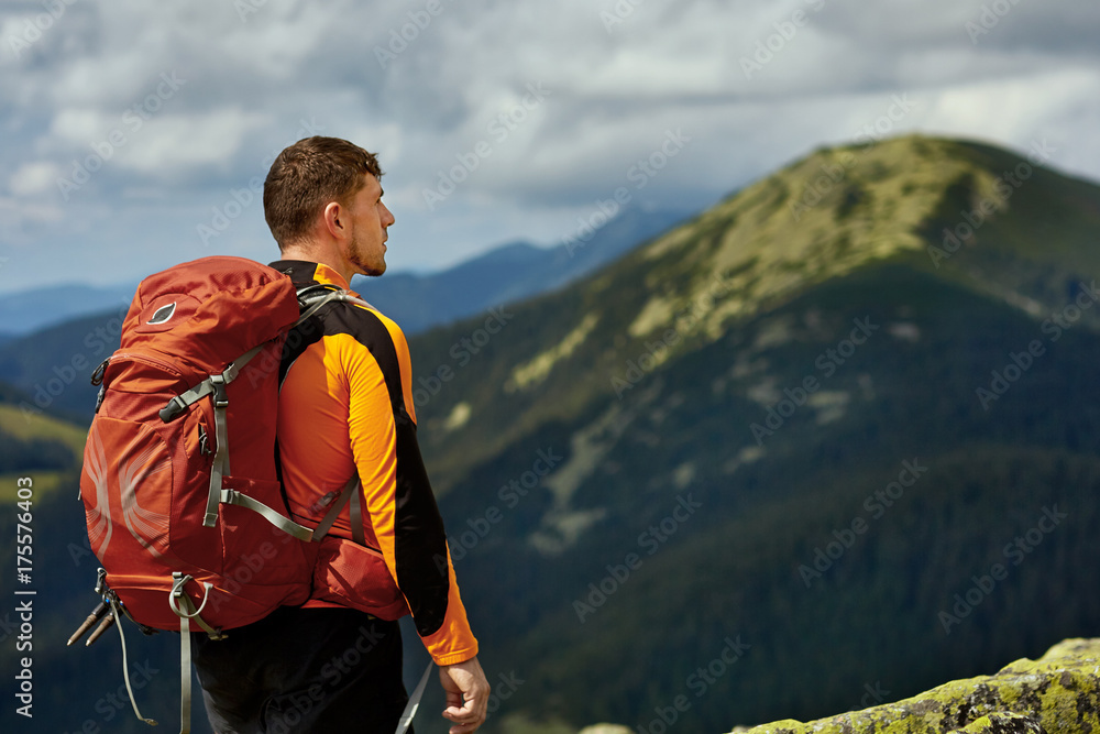 Guy with a travel backpack on the top of a boulder Guy with a travel backpack on the top of a boulder