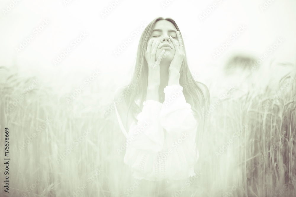 Fototapeta premium Young glamorous model posing in a field wheat