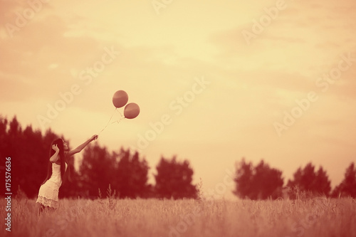 Fototapeta Naklejka Na Ścianę i Meble -  Dream, happiness - young girl in a field with flying balloons