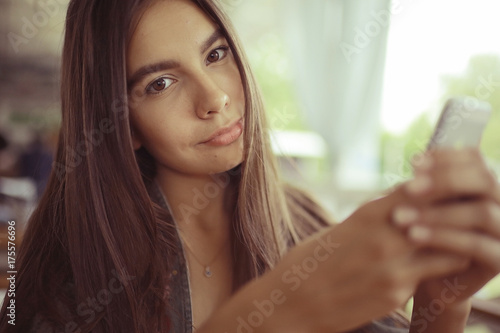 Girl with a phone in a cafe in the summer