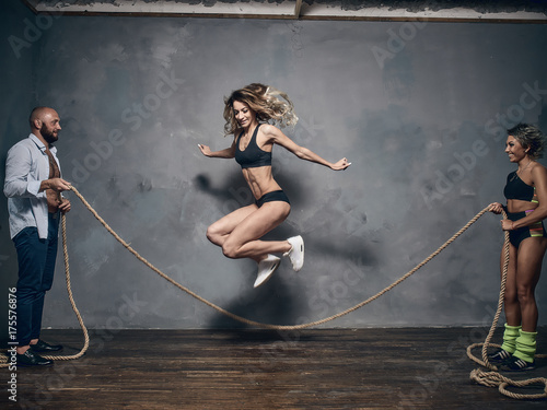 Young people jump through the rope in the photo studio.