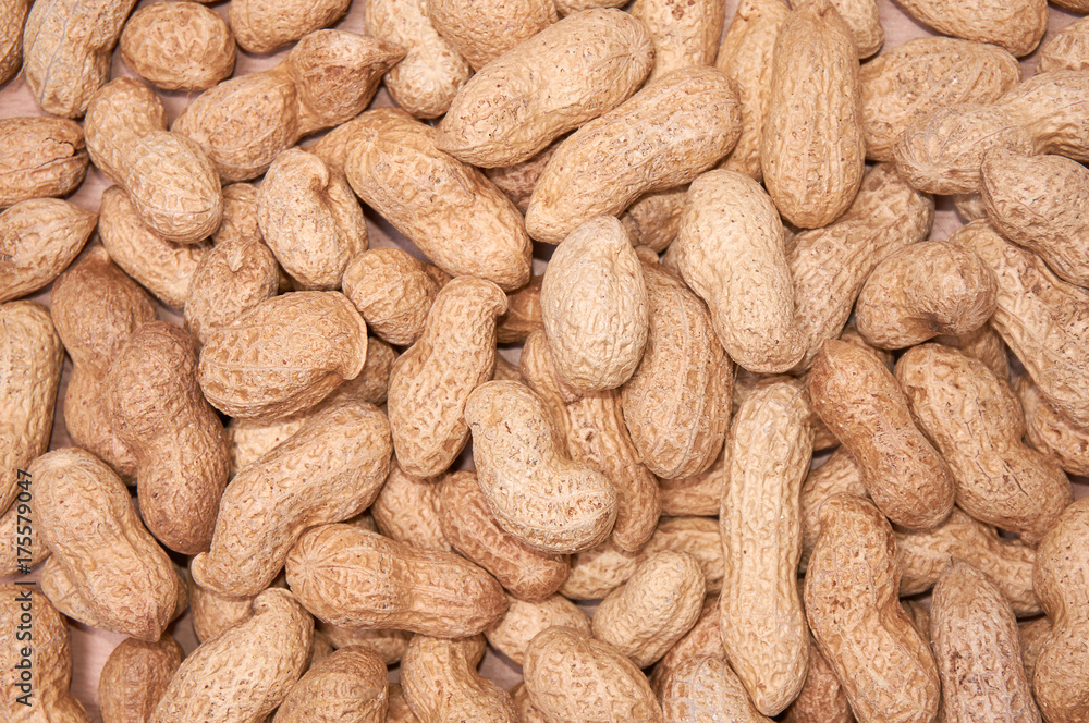 Peanuts in a peel against a light wood background Peanuts in a peel against a light wood background