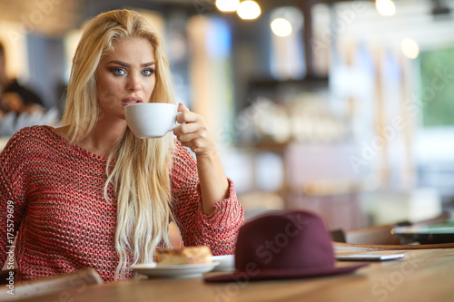 Blonde woman drinking coffee in a cafe