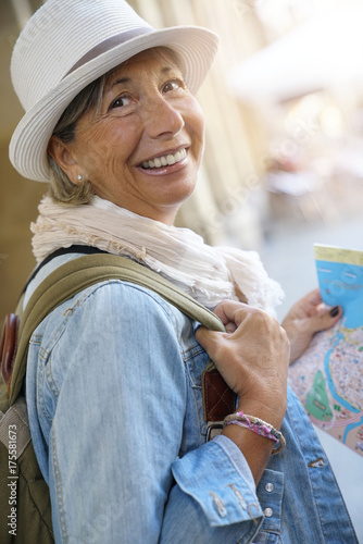 Senior woman traveling in european city, reading map
