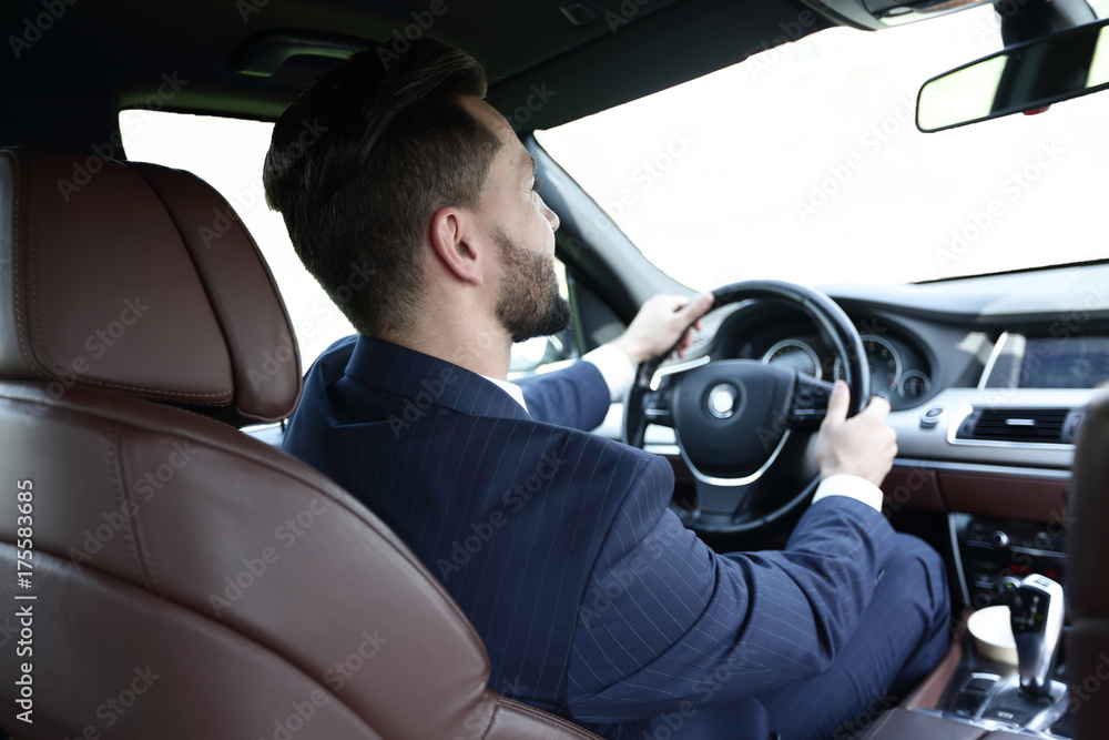 businessman sits at the wheel in his car and looks at the road businessman sits at the wheel in his car and looks at the road