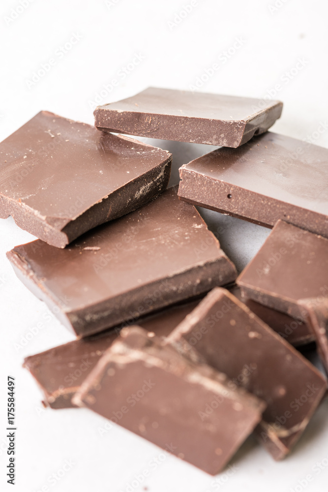 Slices of cooking chocolate on the white marble background table Slices of cooking chocolate on the white marble background table
