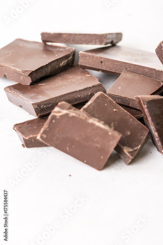 Slices of cooking chocolate on the white marble background table