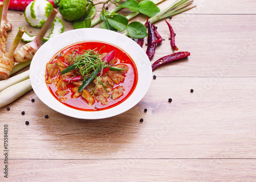 Chicken curry with raw ingredients on wooden background, chicken panaeng curry the delicious of thai food. Copy space.