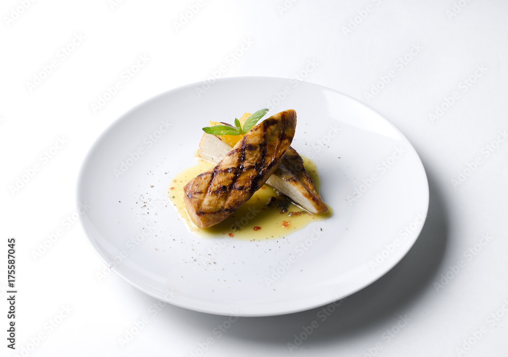 Grilled chicken fillet with orange mint sauce on a white plate
