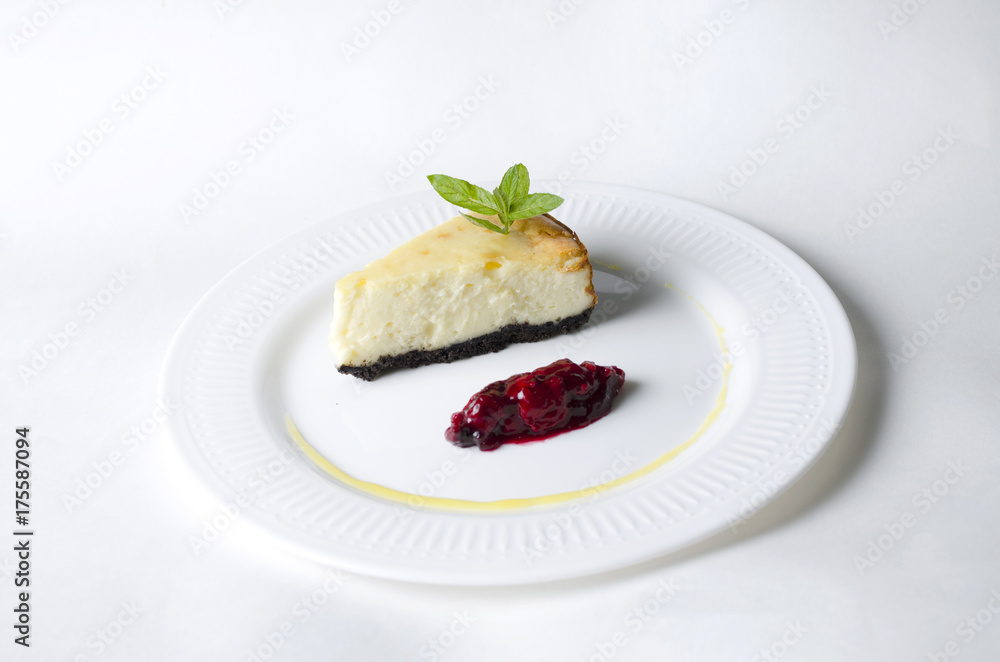 Classic cheesecake with cherry sauce on a white plate Classic cheesecake with cherry sauce on a white plate