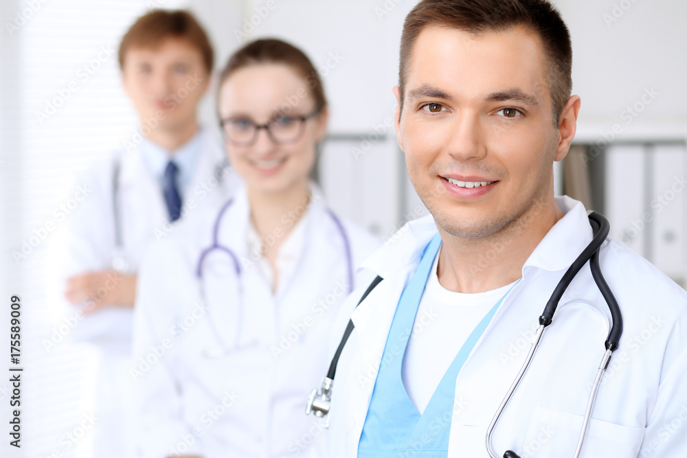 Cheerful smiling male doctor with medical staff at the hospital Cheerful smiling male doctor with medical staff at the hospital