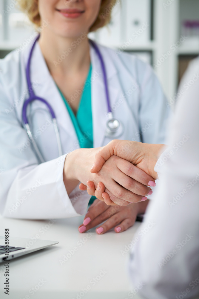 Doctor and patient shaking hands, close-up. Physician talking about medical examination results. Medicine, healthcare and trust concept Doctor and patient shaking hands, close-up. Physician talking about medical examination results. Medicine, healthcare and trust concept