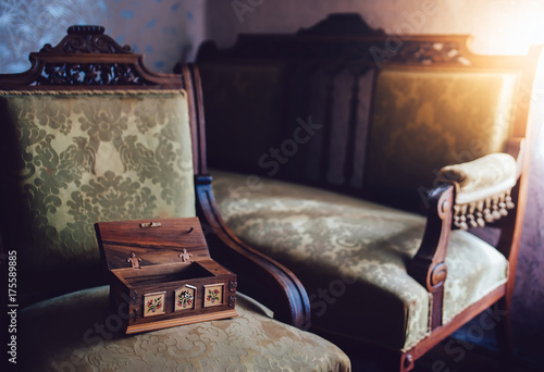 Mysterious wooden music box on the vintage chair. Details of vintage furniture