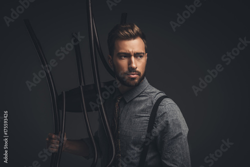 Man posing with wooden chair