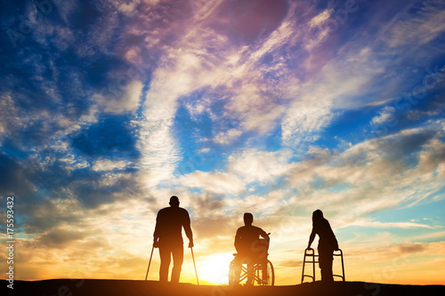 Three disabled people at the sunset. photo