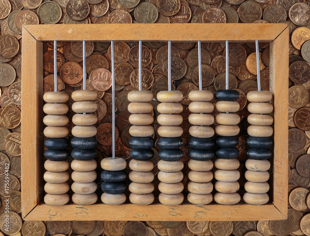 old wooden abacus on coins background old wooden abacus on coins background
