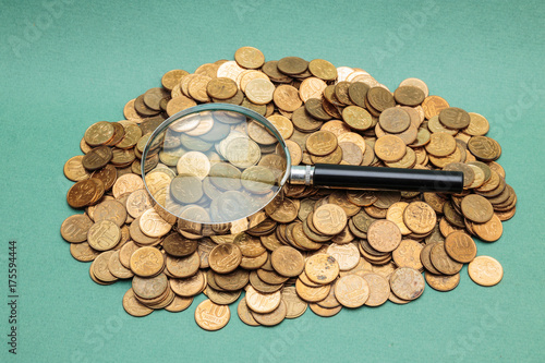 magnifying glass on a heap of coins