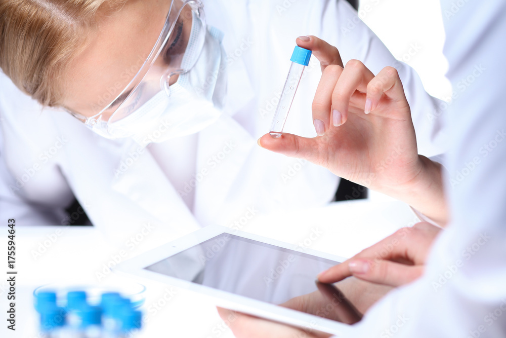 Close-up of scientific research team with clear solution in laboratory Close-up of scientific research team with clear solution in laboratory