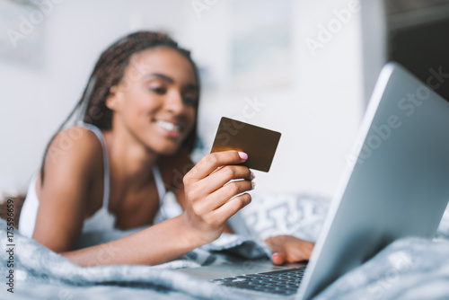 woman making e-shopping in bed