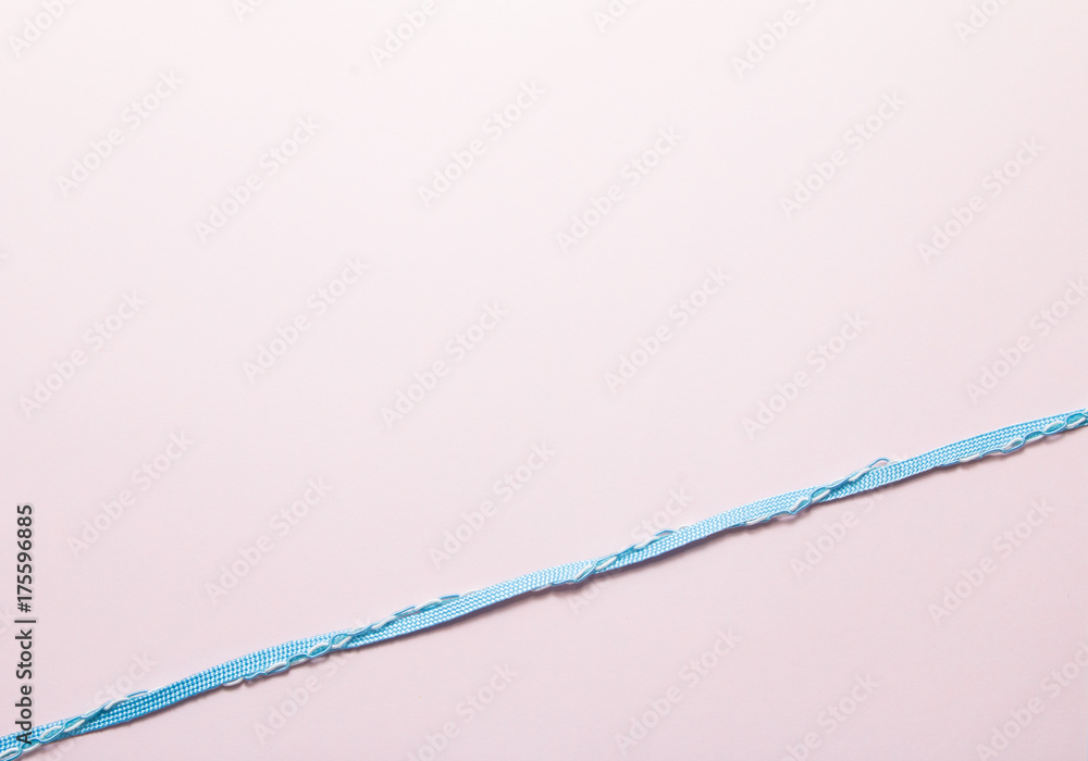Blue ribbon on soft pink paper Blue ribbon on soft pink paper