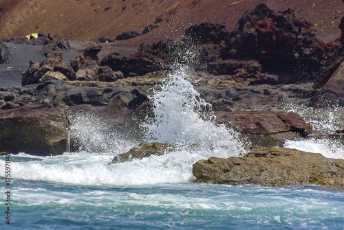 Wellen schlagen gegen Uferfelsen