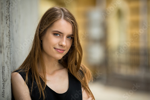 Free Download Attractive young girl standing oitdoors. View of woman with long hair and natural makeup. - GFXLoad