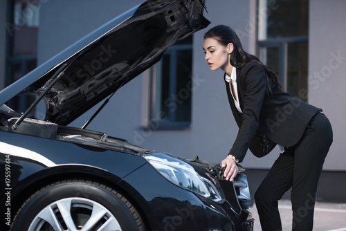 woman looking under hood of car © LIGHTFIELD STUDIOS