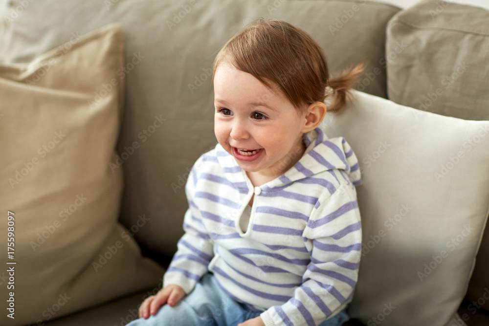 happy smiling baby girl sitting on sofa at home happy smiling baby girl sitting on sofa at home