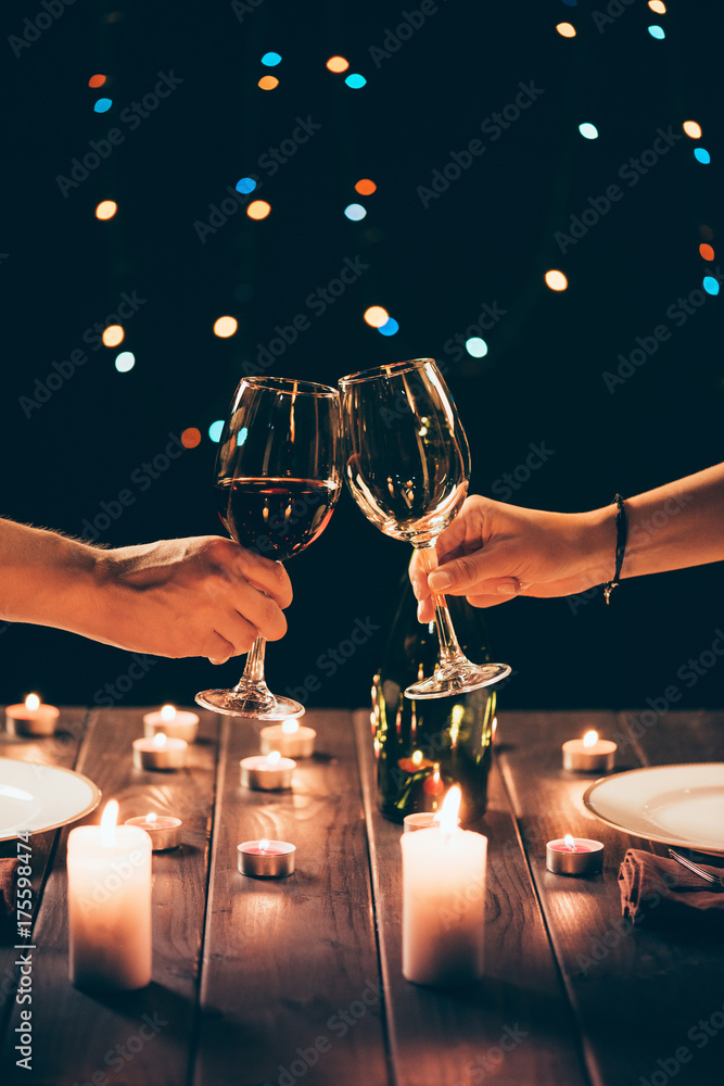Naklejka premium Couple clinking glasses with wine