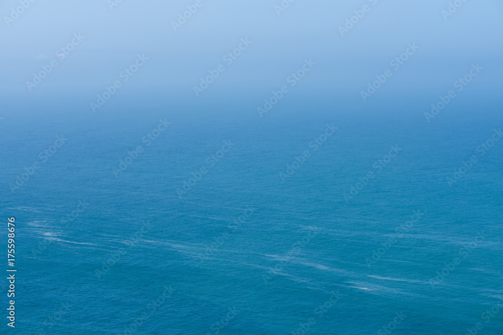 Aerial view of calm infinite ocean and blue sky background