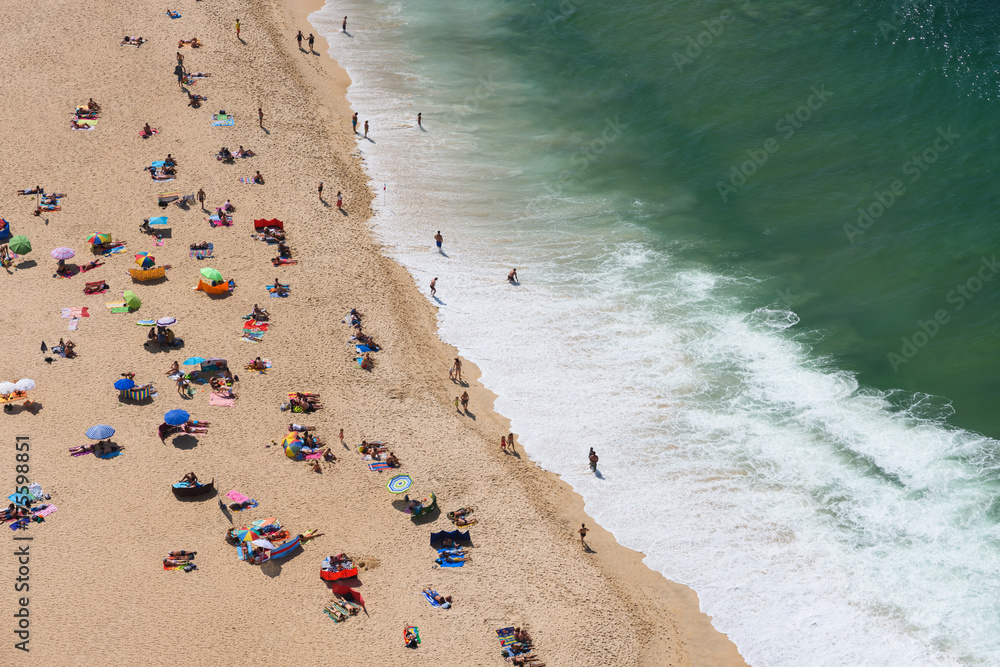 Aerial view of people sunbathing on the ocean beach at hot summer day