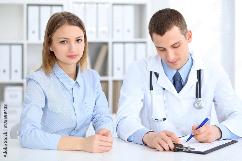 Doctor and patient sitting at the desk. Medicine and health care concept Doctor and patient sitting at the desk. Medicine and health care concept
