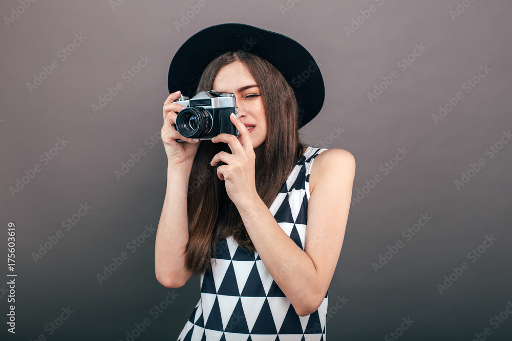 Stylish woman photographer with retro camera on the grey wall background. Image with copy space
Stylish woman photographer with retro camera on the grey wall background. Image with copy space