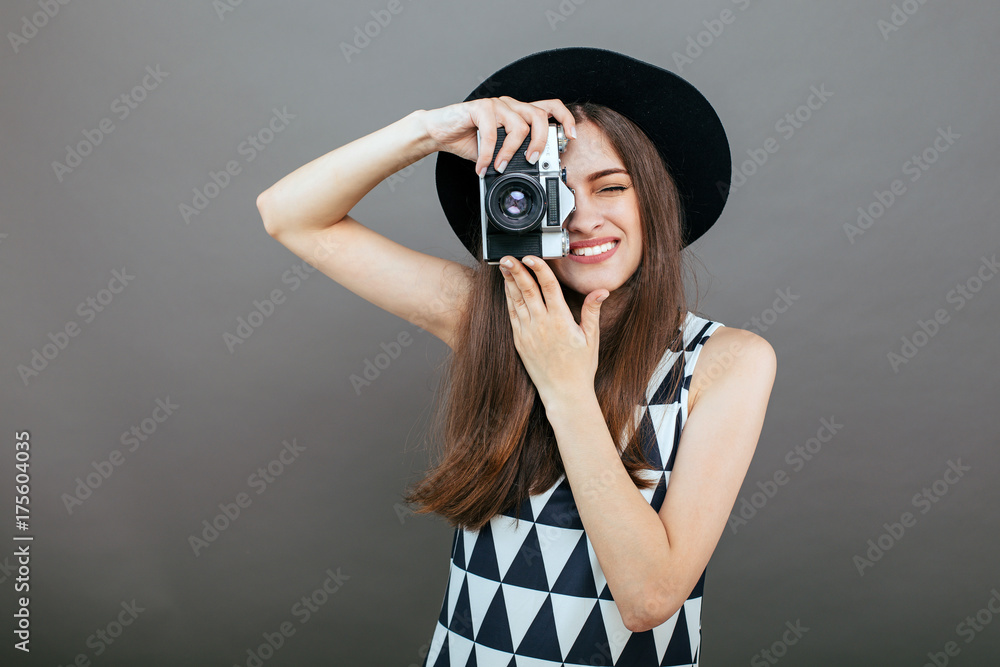 Stylish woman photographer with retro camera on the grey wall background. Image with copy space
Stylish woman photographer with retro camera on the grey wall background. Image with copy space