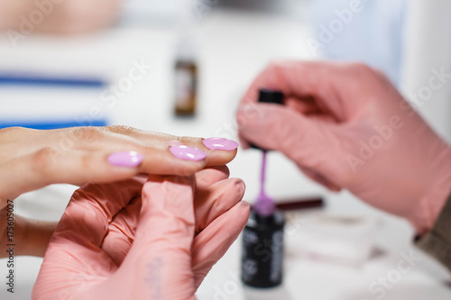 the master in the salon makes a manicure Nail polish coating. A big plan. Beautiful hands