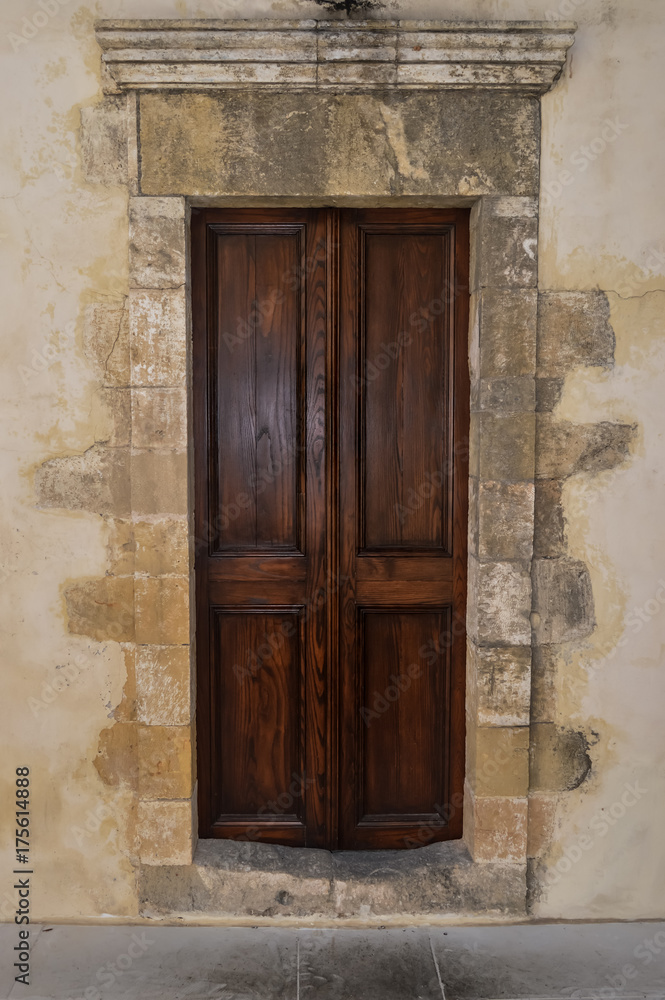 A dark wooden door on a stony wall