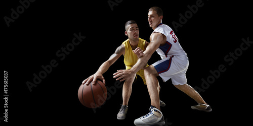 Two basketball players fight for the basketball ball. Isolated basketball players on a black background. Player wears unbranded clothes. © Alex