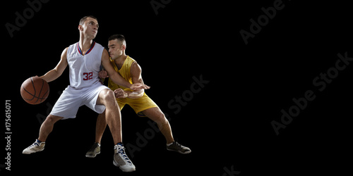 Two basketball players fight for the basketball ball. Isolated basketball players on a black background. Player wears unbranded clothes.