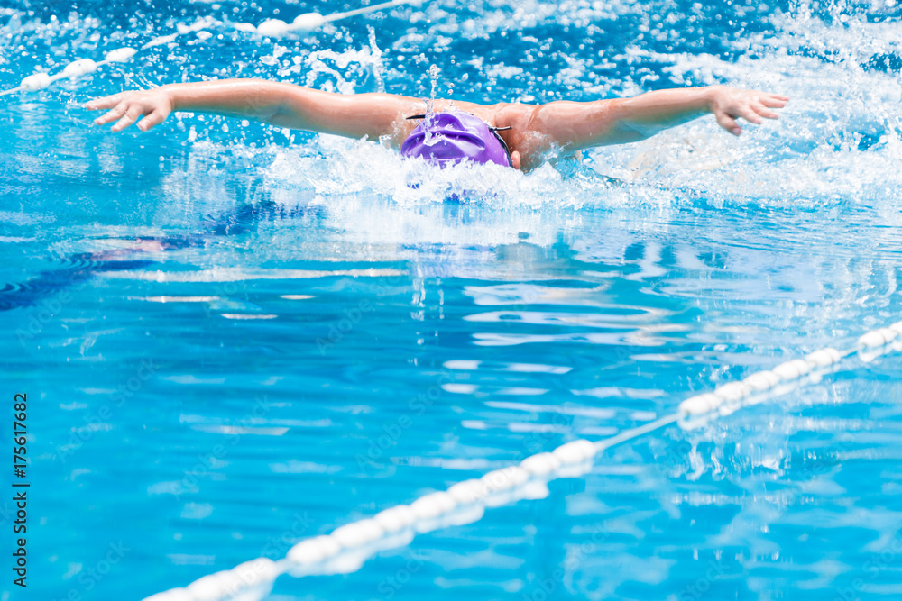 boy swimmer swimming Butterfly stroke in a nice clear swimming pool