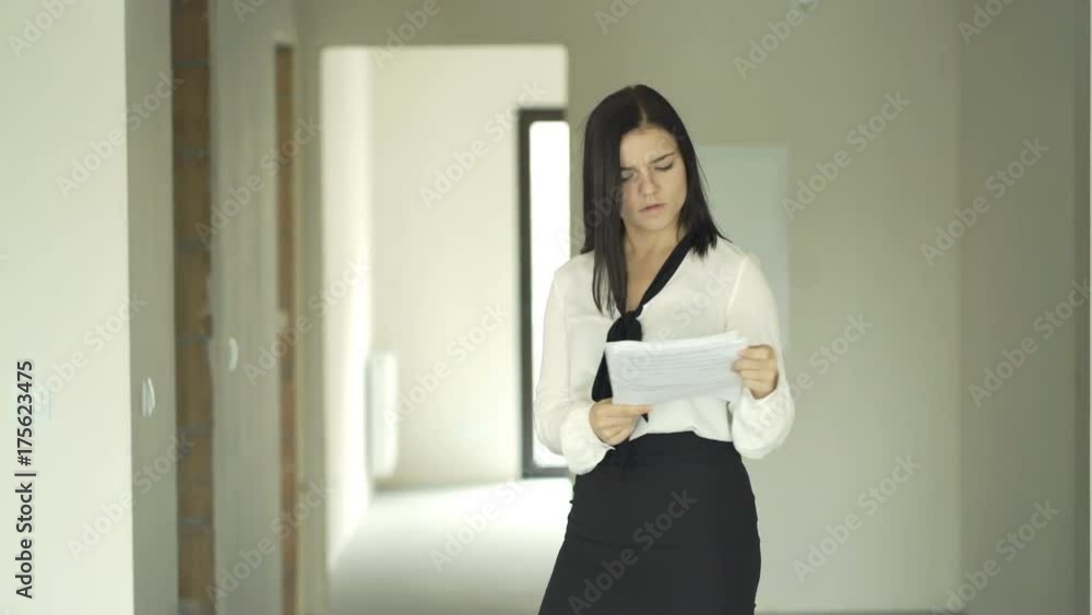Female real estate agent with blueprints checking new home
Female real estate agent with blueprints checking new home