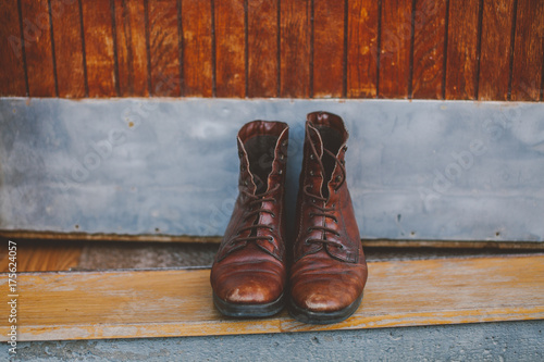 Vinage brown laced  up boots in front of old doors photo