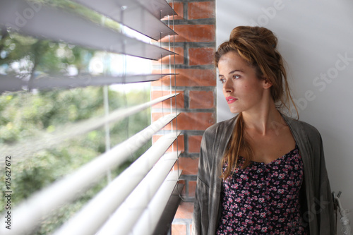 Beautiful girl looking through the window photo