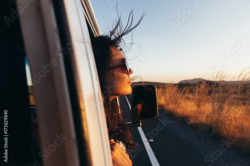 Road Tripping - Beautiful Woman Sticking Head Outside Car Window While Driving photo