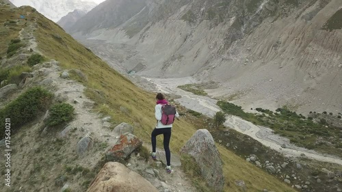 Girl walking along narrow summit ridge crest in the evening