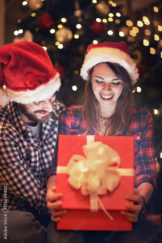 Wife and husband looks in open box with gift for New year Wife and husband looks in open box with gift for New year