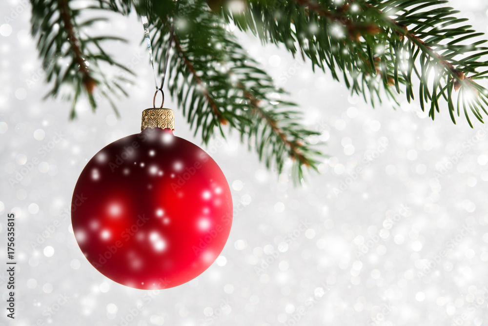 Red decorative ball on the christmas tree on glitter bokeh background with blurred snow. Merry christmas card. Winter xmas theme. Happy New Year. Snowing. Red decorative ball on the christmas tree on glitter bokeh background with blurred snow. Merry christmas card. Winter xmas theme. Happy New Year. Snowing.
