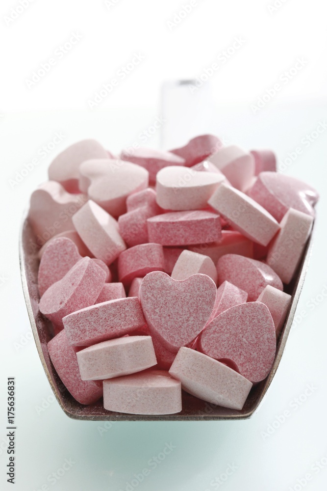 Pink heart-shaped grape sugars, in a little metal shovel Pink heart-shaped grape sugars, in a little metal shovel