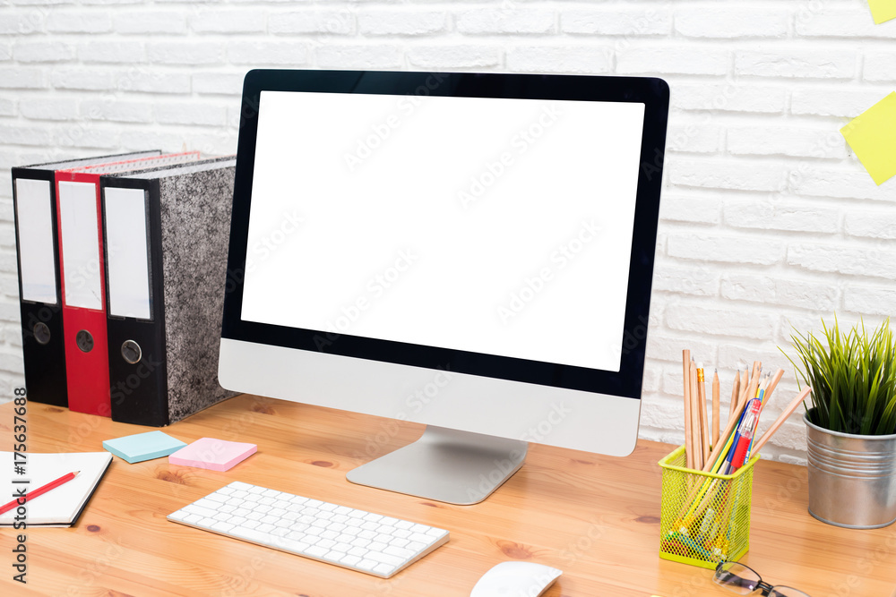 workspace with computer with blank white screen, and office supplies on a wooden desk workspace with computer with blank white screen, and office supplies on a wooden desk
